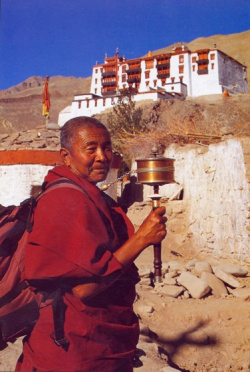 Молитвенное колесо в руках монаха. Фото отсюда.